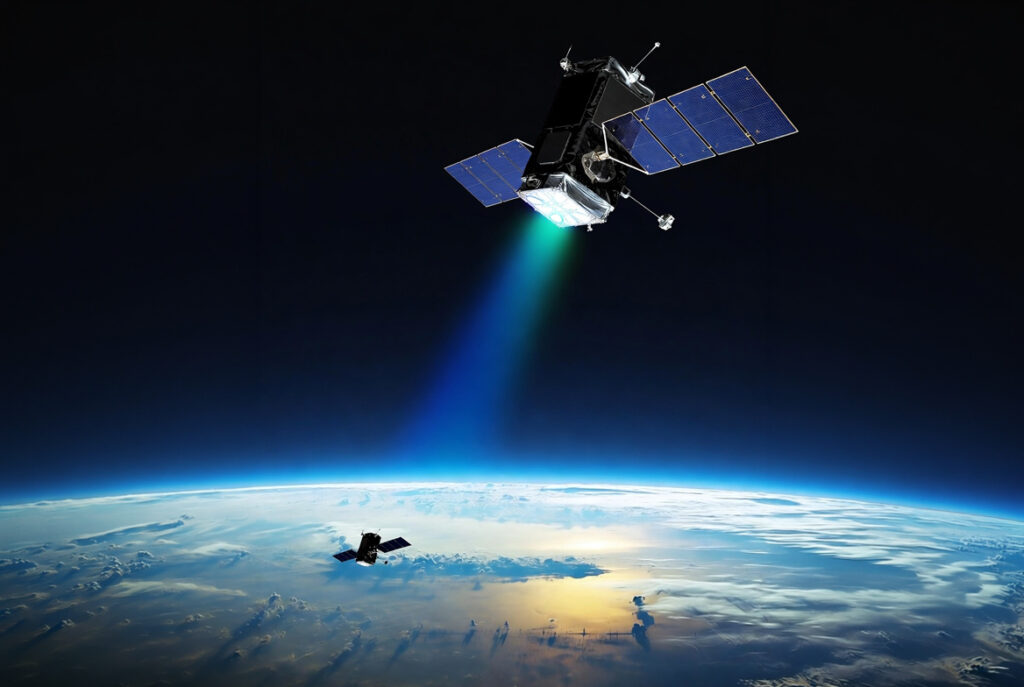 Space-Power-Laser-Beaming-Satellite-Concept | Space Power | Space Power Satellite with solar panels releasing a blue-green engine plume above Earth's curved horizon.